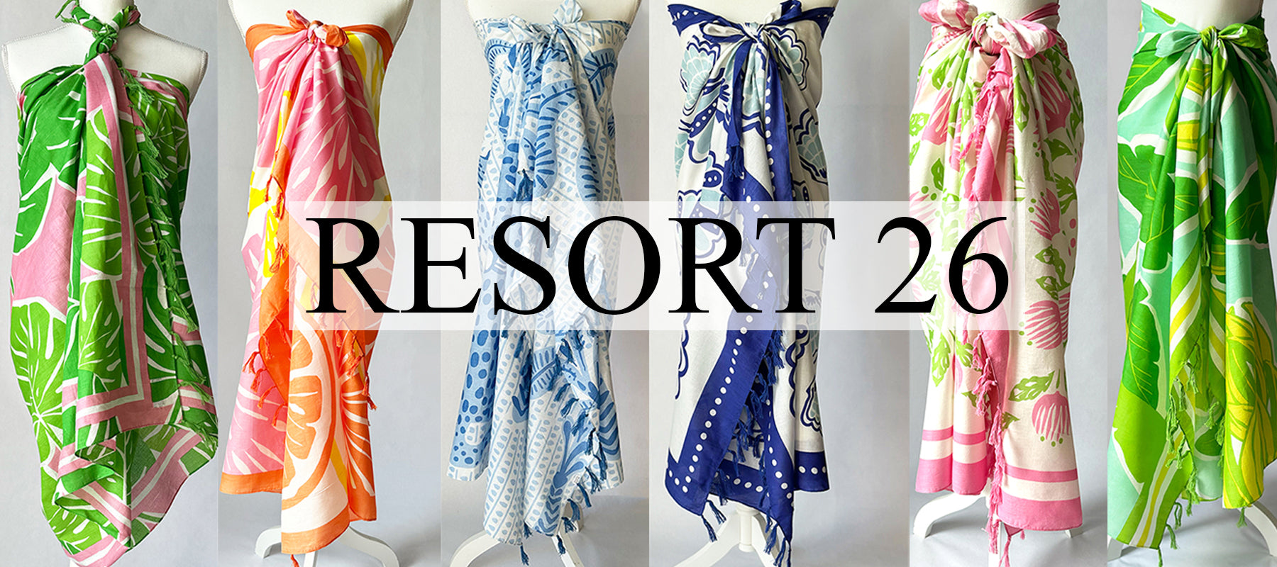 Collection of colorful sarongs on mannequins with 'Resort 26' branding.